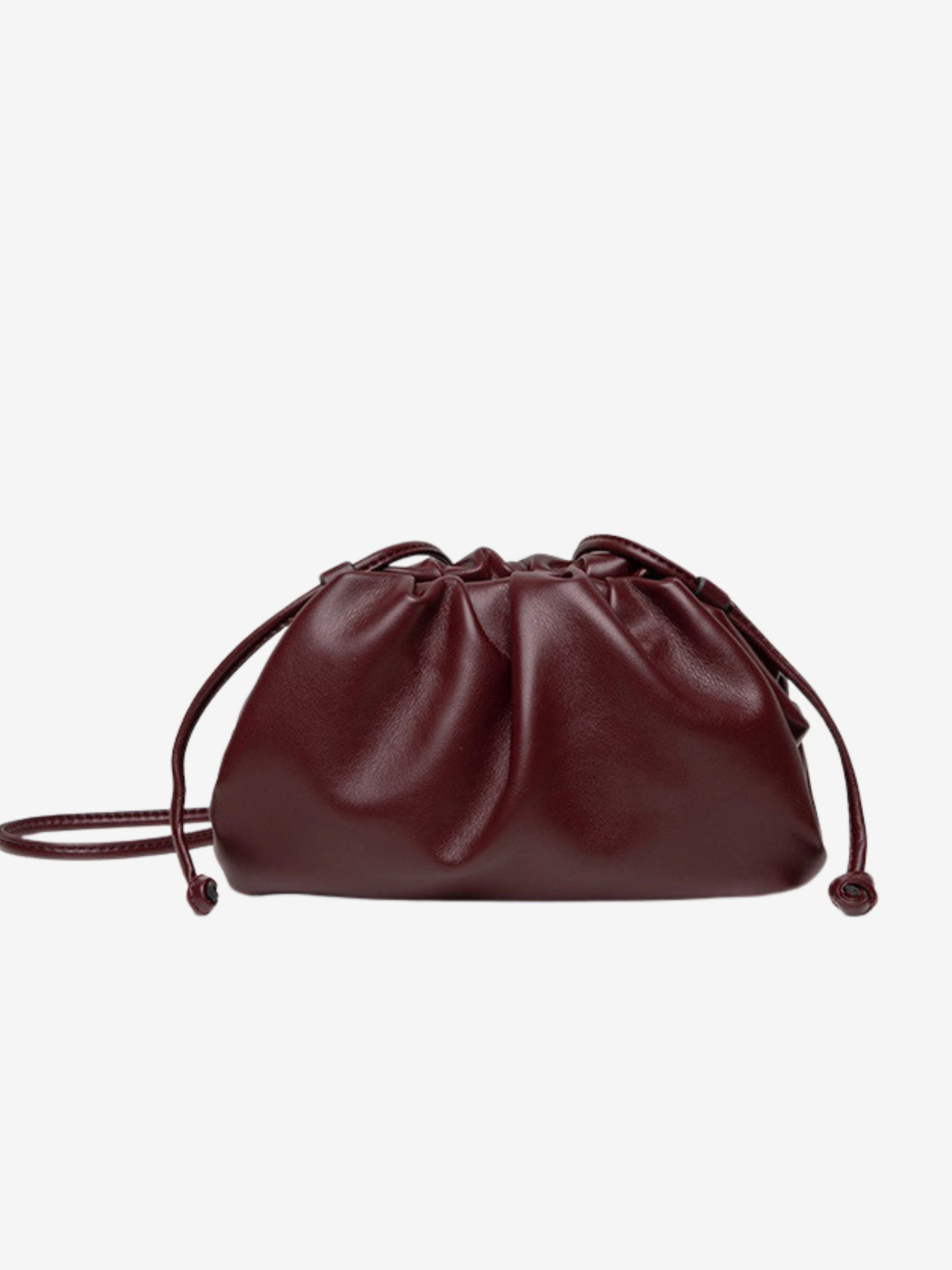 De Serena Zachte Leren Pouch Tas van Liora The Label is een kleine, bordeauxrode tas met een gerimpeld ontwerp en twee trekkoordjes, gemaakt van boterzacht leer, tegen een effen witte achtergrond.