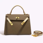 De Jovienne Luxe Teal & Tan Leren Handtas van Liora The Label, met iconisch ontwerp en elegante details, wordt stijlvol gepresenteerd tegen een lichte achtergrond.