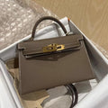 De Galatea, een elegante zwarte leren handtas van Liora The Label, ligt in een open doos met zijdepapier en bubbelplastic; het klassieke ontwerp straalt luxe en functionaliteit uit.