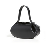 De Guinevere van Liora The Label is een gebeeldhouwde schoudertas van bruin leer met een dikke, gebogen riem en een glad, minimalistisch luxe design, afgebeeld op een witte achtergrond.