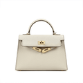 De Galatea van Liora The Label is een elegante zwarte leren handtas met saffiano-textuur, goudkleurige hardware, een top handvat en een voorflap met twee gouden sluitingen. Deze tas combineert klassieke luxe met functionele stijl.