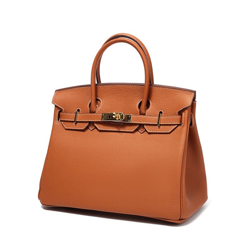 De Isla Tan Textured Leather Handtas van Liora The Label heeft twee hengsels, een goudkleurige gesp en een kiezelachtige afwerking. Tegen een witte achtergrond belichaamt het de klassieke stijl van Klassiek & Tijdloos.