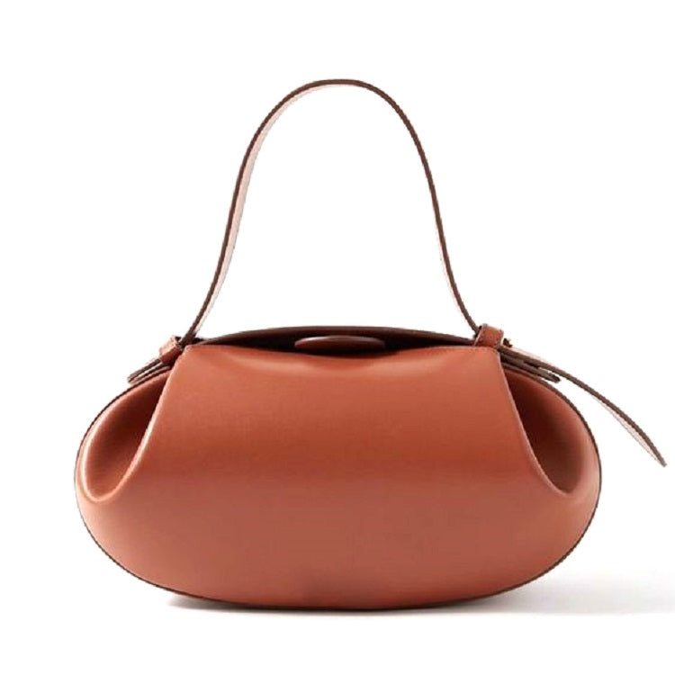 De Guinevere Sculpted Bruine Leren Schoudertas van Liora The Label combineert moderne elegantie met artistieke raffinement. De ovale vorm, korte greep en gladde leer stralen minimalistische luxe uit tegen een witte achtergrond.