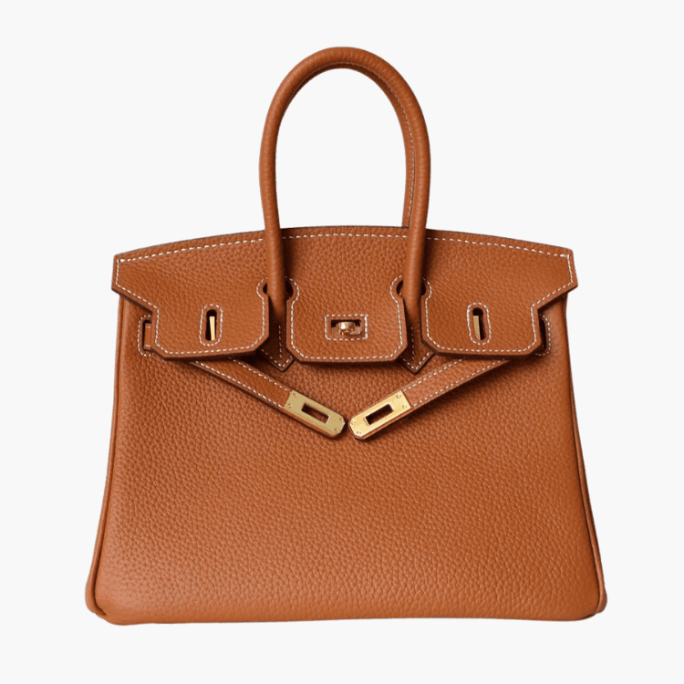 De Isla Tan Textured Leather Handtas van Liora The Label heeft dubbele handvatten, witte stiksels en goudkleurige hardware met slot en sluitingen. Weergegeven op een witte achtergrond voegt deze tas tijdloze elegantie toe aan elke look.