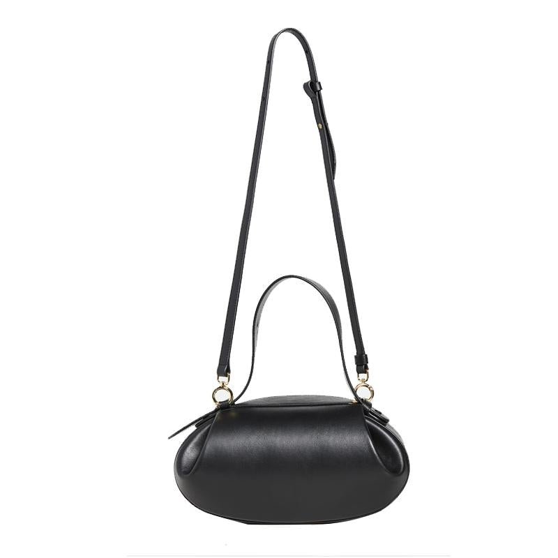 De Guinevere van Liora The Label is een gesculpteerde bruine leren schoudertas met afgeronde vorm, korte handgreep en verstelbare schouderriem met goudkleurige accenten voor een minimalistische luxe uitstraling.