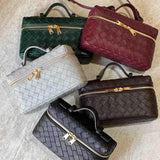 Vijf luxe Geweven Box Tassen van Liora The Label, waaronder een elegante donkerbruine crossbody met gouden ritssluiting, worden getoond op een licht oppervlak. Elke tas heeft een veganistische leer met slotdetail en een bovenhandgreep voor tijdloze allure.