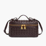 De Luxe Geweven Box Bag van Liora The Label is een elegante, donkerbruine crossbody tas van vegan leer met gevlochten design, goudkleurige ritssluiting met dubbele trekker, bovenhandgreep en verstelbare schouderriem.